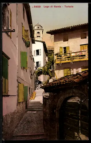 AK Torbole /Lago di Garda, Pittoresca via con edifici tradizionali e campanile in lontananza