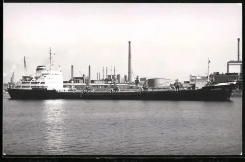 Fotografie Sowjetisches Frachtschiff Domatovo im Hafen vor Fabrikanlage und Öltanks