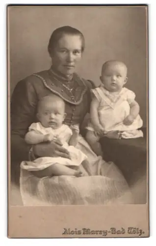 Fotografie Alois Marey, Bad Tölz, Porträt einer Frau mit zwei Kleinkindern in den Armen, Mutterglück
