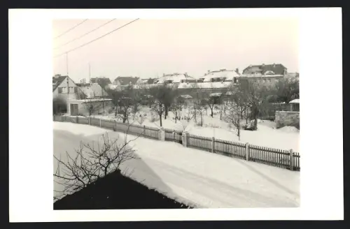 Fotografie unbekannter Fotograf, Ansicht Zörbig, Winterliche Strassenszene mit schneebedeckten Dächern 1963