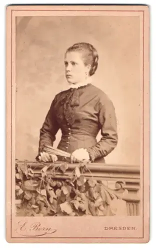 Fotografie E. Born, Dresden, Pragerstrasse 5, Frau mit elegantem Kleid an Geländer