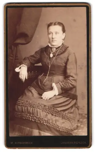 Fotografie M. Hirschbeck, Landsberg am Lech, Sitzende Dame mit elegantem Kleid