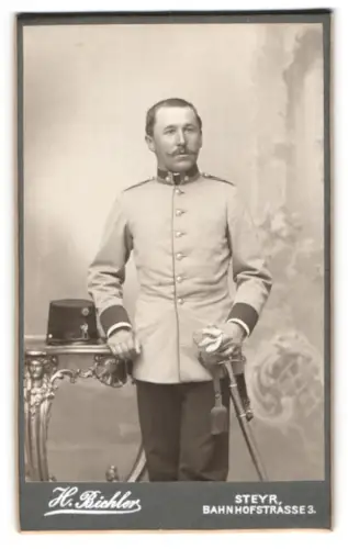 Fotografie H. Bichler, Steyr, Bahnhofstrasse, k.u.k. Offizersstellvertreter in Uniform mit Kappe und Säbel
