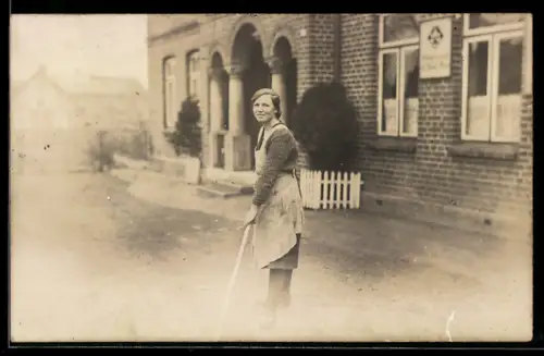 Foto-AK Tensfeld, Junge Dame mit Besen in der Hand vor einem Haus