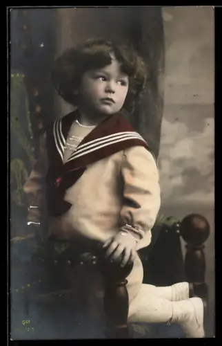 Foto-AK GG Co.: kleines Kind im Matrosenanzug kniet auf einem Stuhl