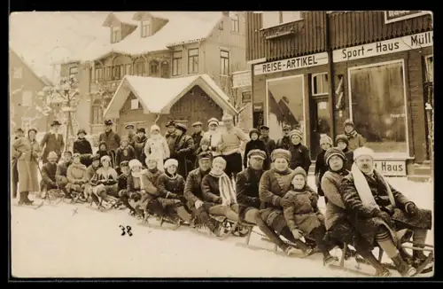 Foto-AK Braunlage, Urlaubergruppe auf Rodelschlitten vor dem Sporthaus Müller, 1922