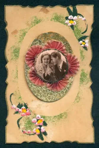 Oblaten-AK Portrait eines jungen Paares, umgeben von Blumen