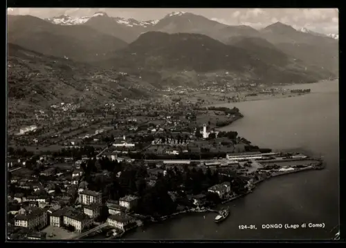 AK Dongo /Lago di Como, Veduta aerea del paese con montagne sullo sfondo