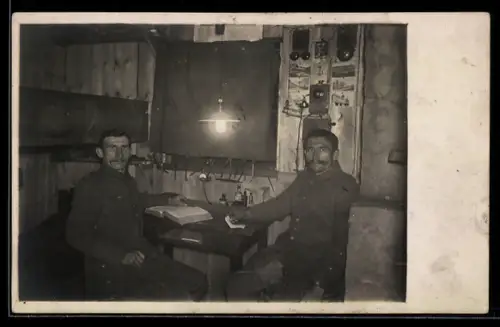 Foto-AK Soldaten auf Freiwache in einer Unterkunft, Schützengraben, Ansichtskarten an der Wand