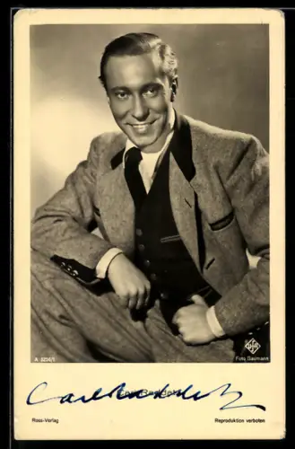 AK Schauspieler Carl Raddatz lächelnd mit aufgestützem Bein, Autograph