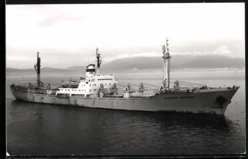Fotografie Sowjetisches Frachtschiff Krasnyi Oktyabr mit Schwergut-Ladebäumen auf Reede