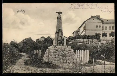 AK Doboj, Denkmal mit Obelisk und Brunnen vor Häusern