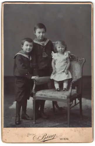 Fotografie Atelier Bing, Wien, Goldschmidgasse 4, Zwei Jungen in Matrosenanzügen und kleines Mädchen auf Stuhl