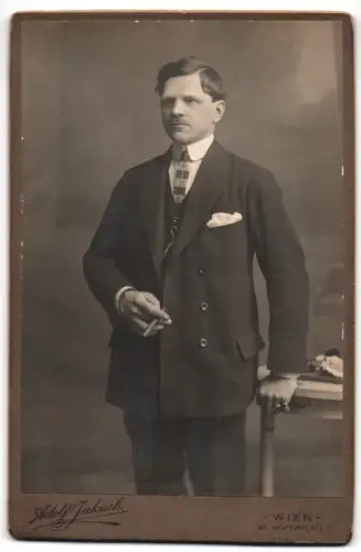 Fotografie Adolf Jakisch, Wien, Nordbahnstrasse 8, Porträt eines Herrn im Anzug mit Zigarillo