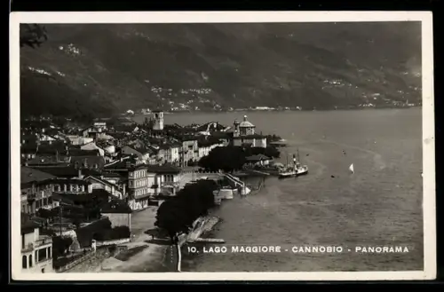 AK Cannobio /Lago Maggiore, Panorama del lungolago con barca a vela e montagne sullo sfondo