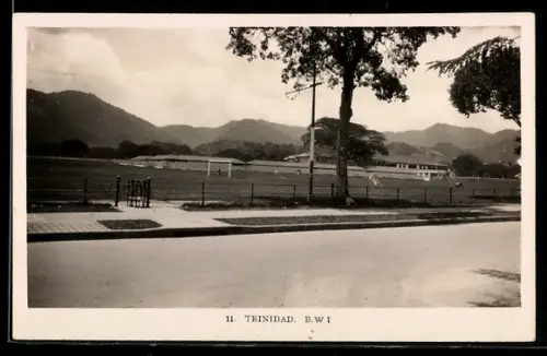 AK Trinidad, Rasenplatz mit Tribüne und Bergen im Hintergrund