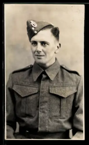 AK Britischer Soldat in Uniform mit verdeckter Knopfleiste und Feldmütze mit Abzeichen