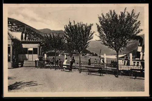 AK Cernobbio /Lago di Como, Imbarcadero con persone e alberi sullo sfondo del lago