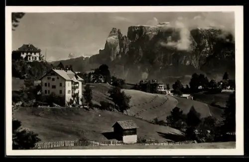 AK Collalbo, Vista panoramica del Renon con case e montagne sullo sfondo