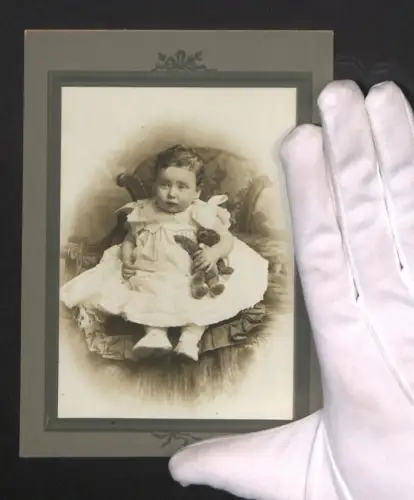 Fotografie Kleinkind im Kleid mit einem Teddybären