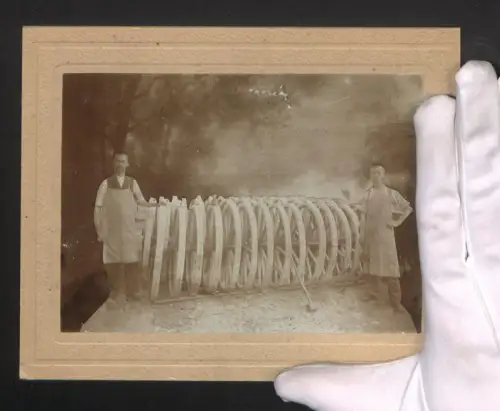 Fotografie Zwei Stellmacher mit Rädern zwischen sich