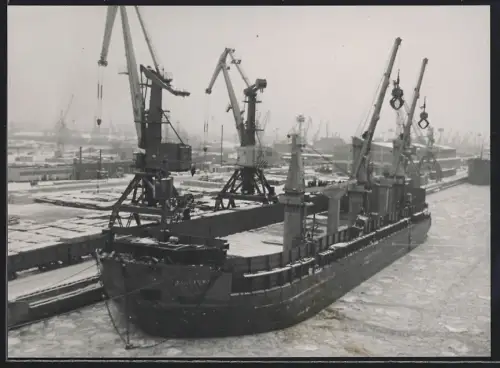 Fotografie Sowjetisches Frachtschiff mit Schwergut-Ladebäumen im vereisten Hafen