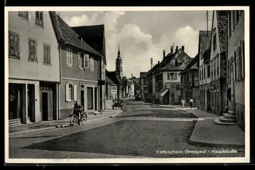 AK Herbolzheim /Breisgau, Hauptstrasse mit Geschäften u. Turmgebäude, Radfahrer