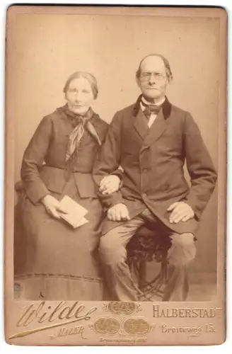 Fotografie O. Wilde, Halberstadt, Breiteweg 15, Älteres Paar auf einem Stuhl sitzend