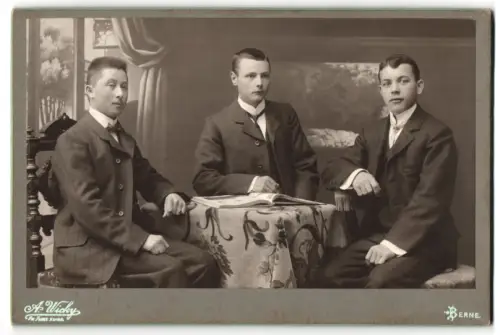 Fotografie A. Wicky, Berne, Schanzenstrasse 6, Drei junge Männer an einem Tisch