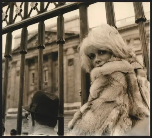 Fotografie Schauspielerin Mireille Darc neben einem Zaun