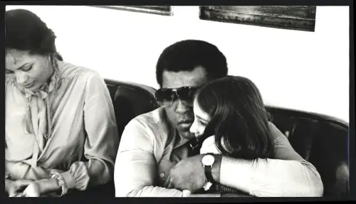 Fotografie Boxer Muhammad Ali mit Sonnenbrille umarmt ein Kind, Grossformat 25 x 14cm