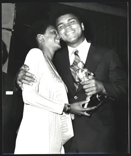 Fotografie Boxer Muhammad Ali mit einem Pokal in der Hand und einer Frau im Arm, Grossformat 21 x 25cm
