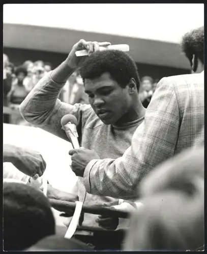 Fotografie Boxer Muhammad Ali an einem Mikrofon mit einem Kamm in der Hand, Grossformat 21 x 25cm