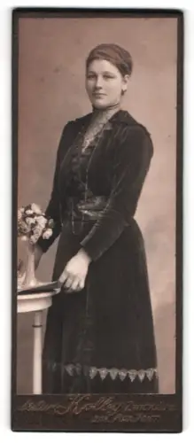 Fotografie Atelier Kolby, Zwickau i. S., Porträt einer jungen Frau mit Blumenarrangement