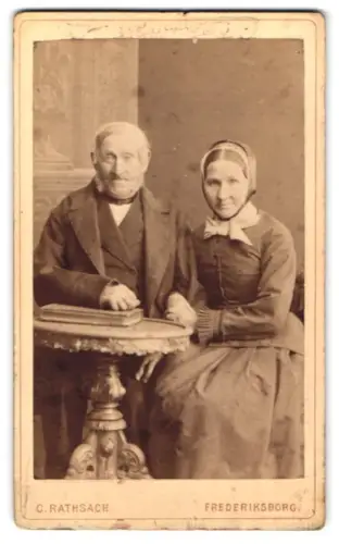 Fotografie C. Rathsach, Frederiksborg, Würdevolles älteres Paar an einem Tisch