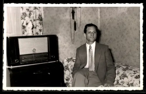 Foto-AK Mann sitzt neben einem Radio auf dem Sofa