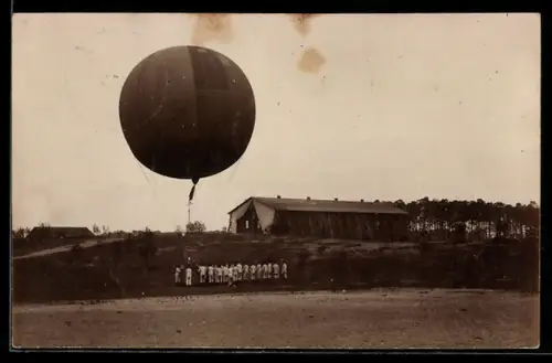 Foto-AK Heissluftballon mit Menschengruppe auf einem Feld
