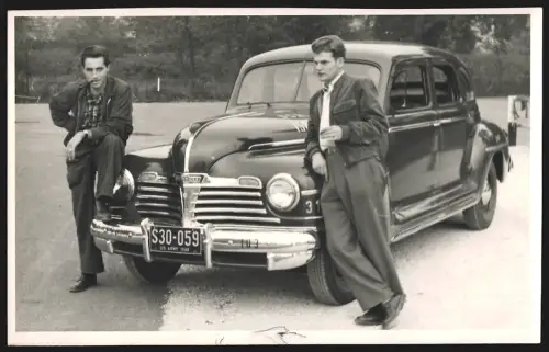 Fotografie unbekannter Fotograf und Ort, Zwei Männer lehnen an einem US-Army 1949 Plymouth