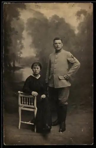 Foto-AK Soldat und eine Frau vor idyllischer Studiokulisse 1916