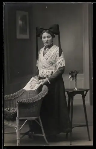 Foto-AK Dame in Tracht vor Studiokulisse einer Stube