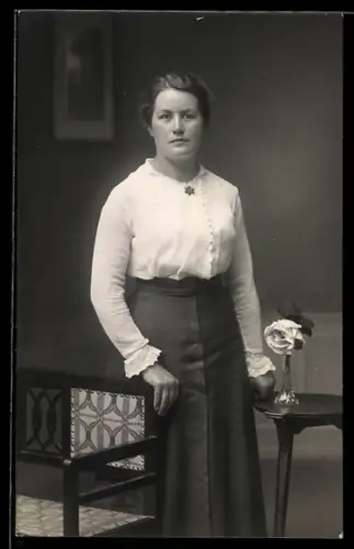 Foto-AK Elegante junge Frau vor Studiokulisse einer Stube
