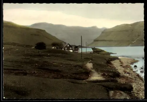 AK Sundi, Häuser am Ufer mit Bergen im Hintergrund