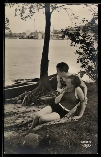 AK Junges Paar in Badeanzügen an einem Seeufer, Boot, Ortschaft