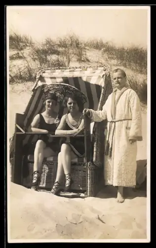 Foto-AK Herr im Bademantel u. junge Damen im Badeanzug im Strandkorb vor Dünen