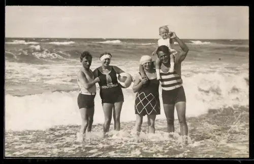 Foto-AK Zwei Paar in Badeanzügen mit Kleinkind im flachen Wasser am Meer