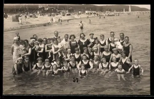 Foto-AK Grosse Gruppe in Badeanzügen im Wasser der See, Strand im Hintergrund