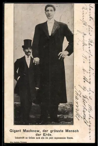 AK Der Riese Machnow neben einem Mann mit Zylinder und Schnurrbart