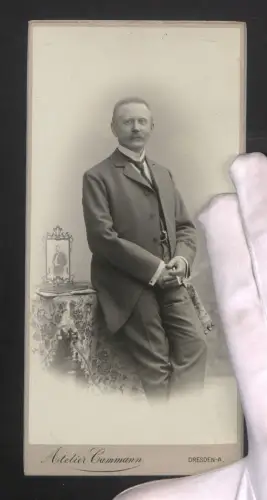 Fotografie Atelier Dammann, Dresden, Elisenstrasse 71, Elegante Mann im Anzug lehnt an einem Tisch
