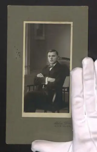 Fotografie Atelier Globus, Pilsen, Junger Mann im Anzug mit verschränkten Armen