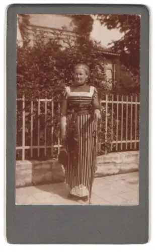 Fotografie unbekannter Fotograf und Ort, Lina Kohlstock vor einem Gartenzaun